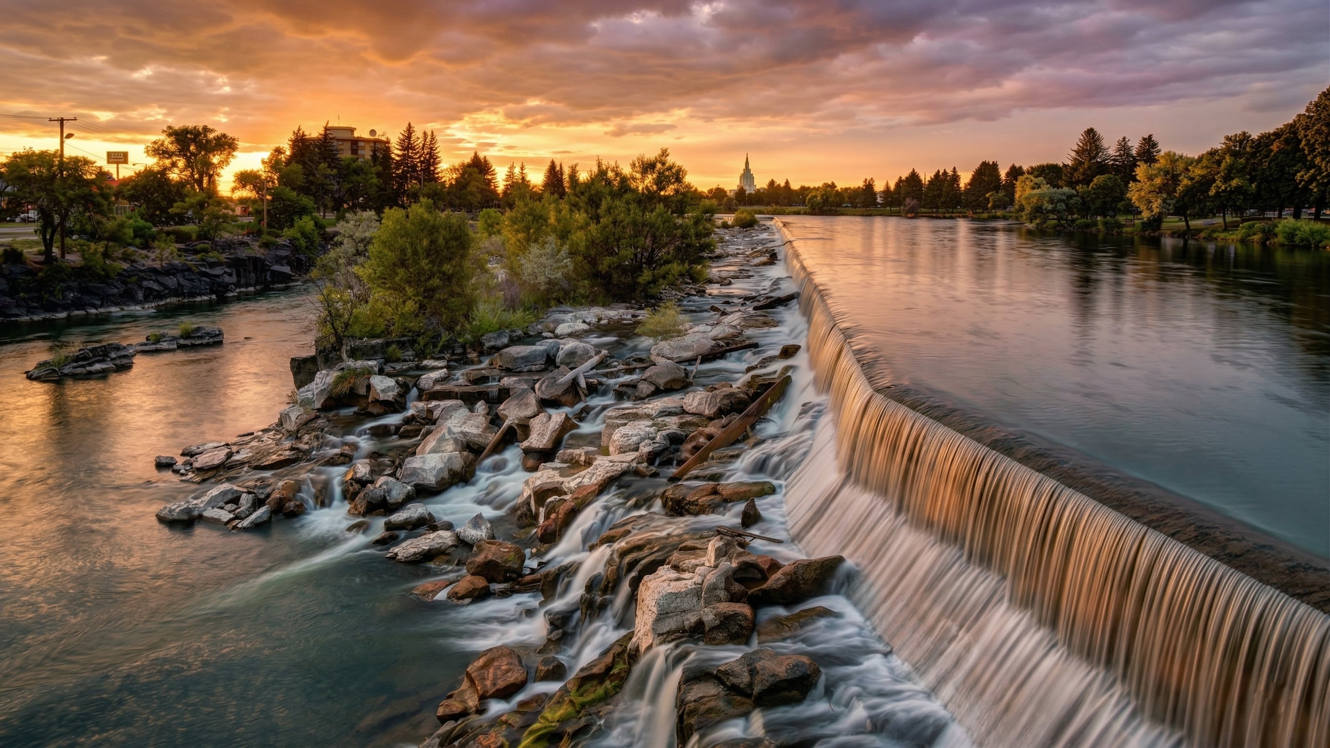 Idaho Falls skyline with the Snake River waterfall at sunset