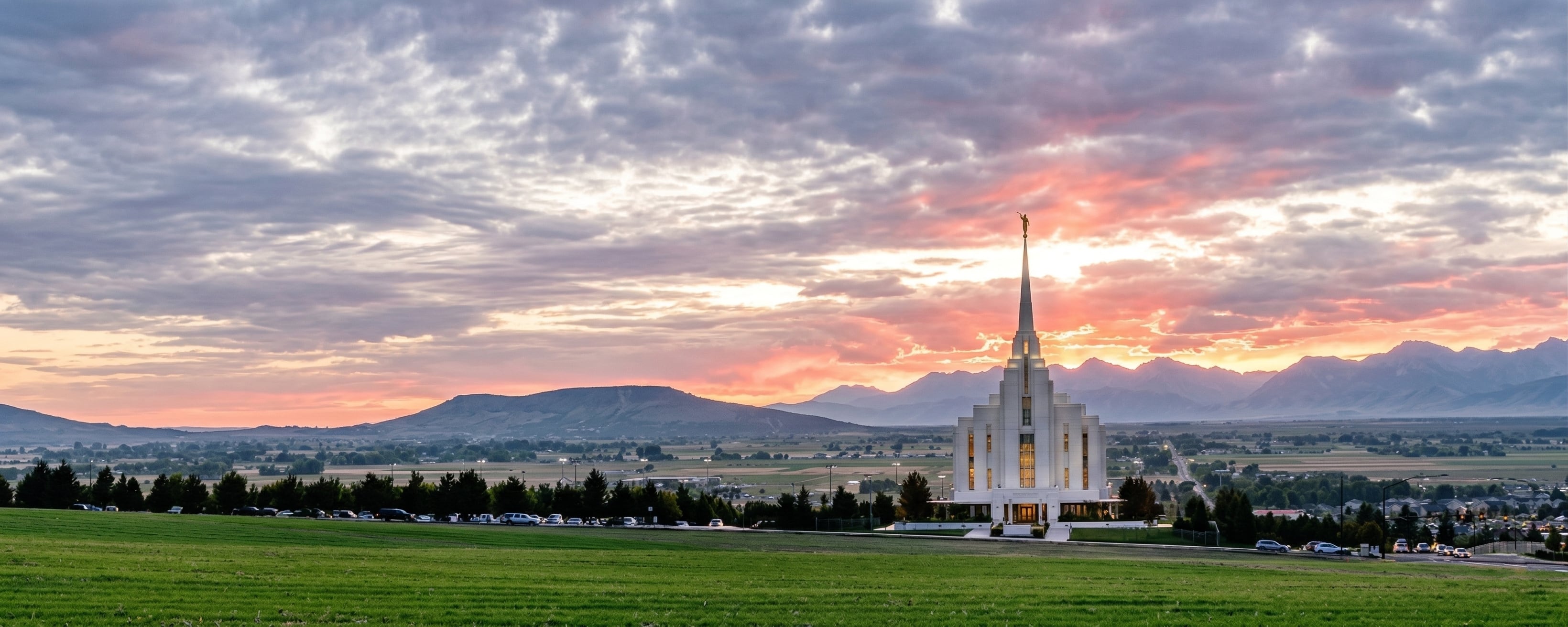 Rexburg Idaho Temple at sunset with mountains in the background